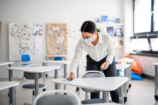 a woman cleaning a school desk