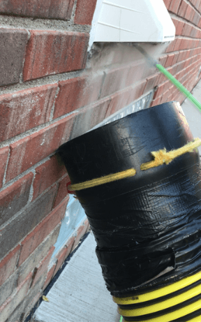 Professional dryer vent cleaning service hose that is cleaning the vent from outside.