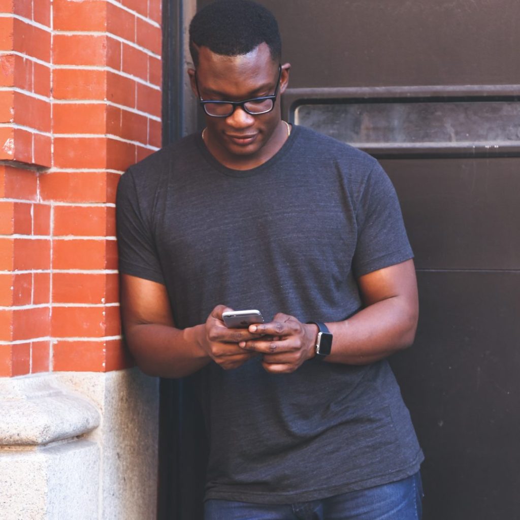 A man using his phone to learn how to spot air duct cleaning scams on social media